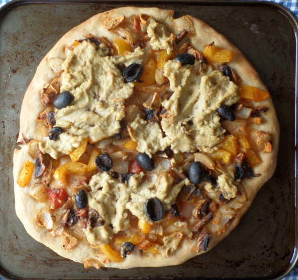 pizza topped with veg and chickpea-sunflower spread